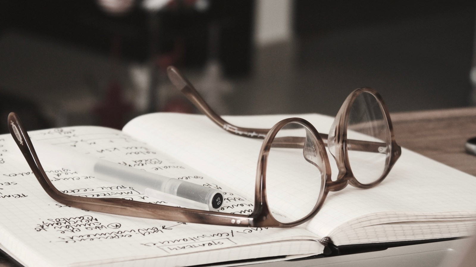 En bild på ett par glasögon som ligger på ett skrivblock
